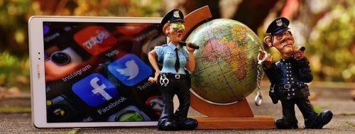 Stilleben mit Globus, Tablet und Polizeifiguren zu Online Recht