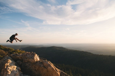 Person springt auf einem Berg