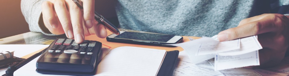 Controller am Arbeitsplatz mit Taschenrechner und Belegen