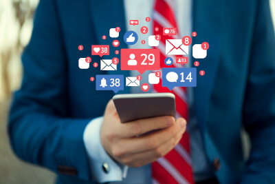 Business-Mann mit Smartphone in der Hand nutzt Social Media