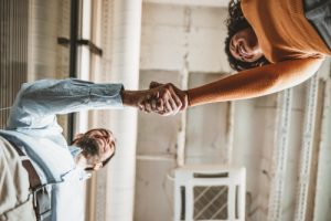 Mitarbeiter und Chefin schütteln sich die Hand auf Augenhöhe