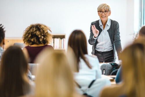Dozentin im Lehrmodus blickt auf Seminargruppe