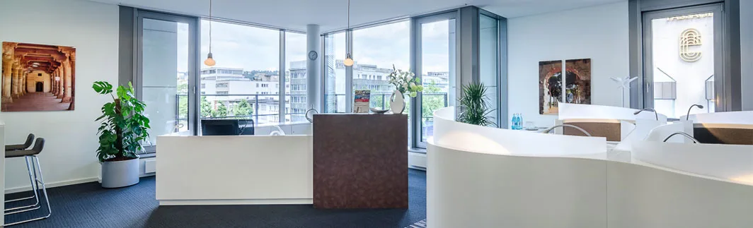 Moderner heller Empfangsbereich im Büro mit weißen Rezeptionstresen, großen Fenstern, Pflanzen und Stadtblick.